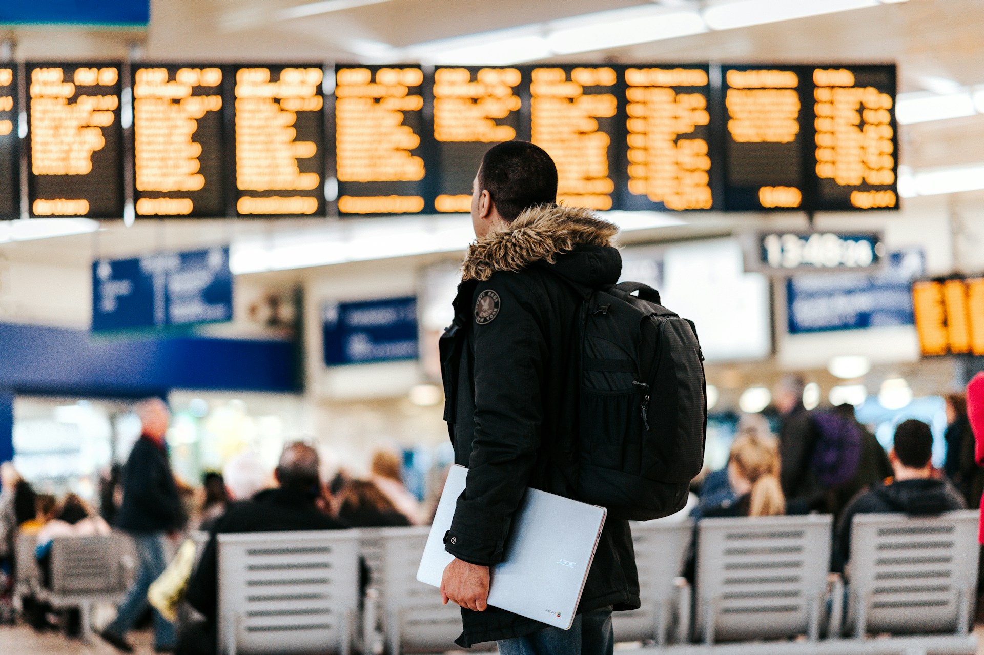 Person looking up at bulletins at a busy airport