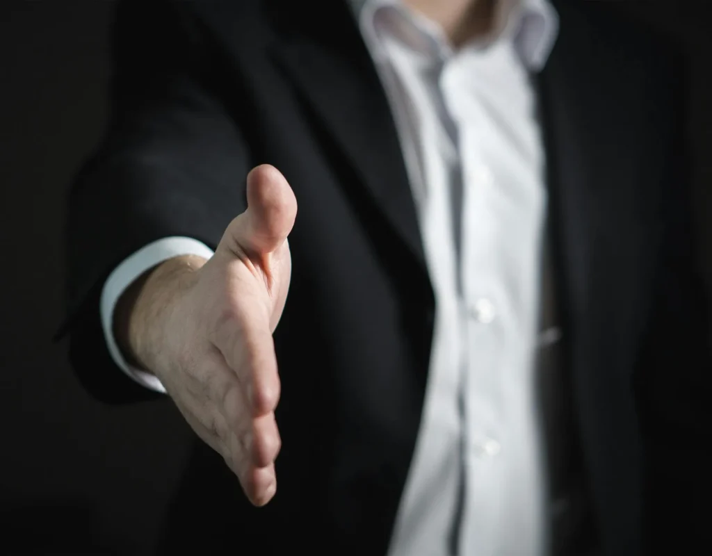 An attorney extends a hand to congratulate a client