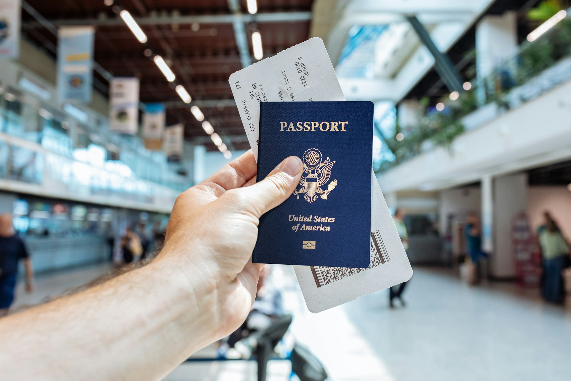 Person holding up a U.S. Passport in an airport