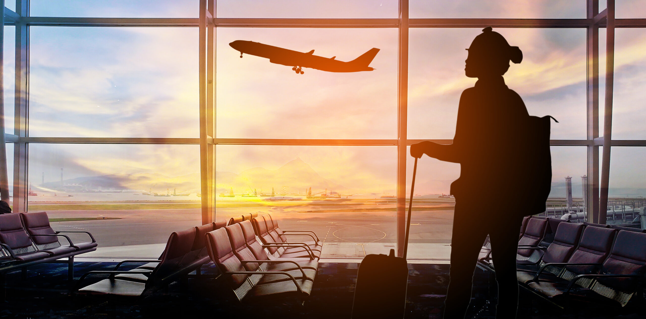 Woman at an airport looking at an airplane.